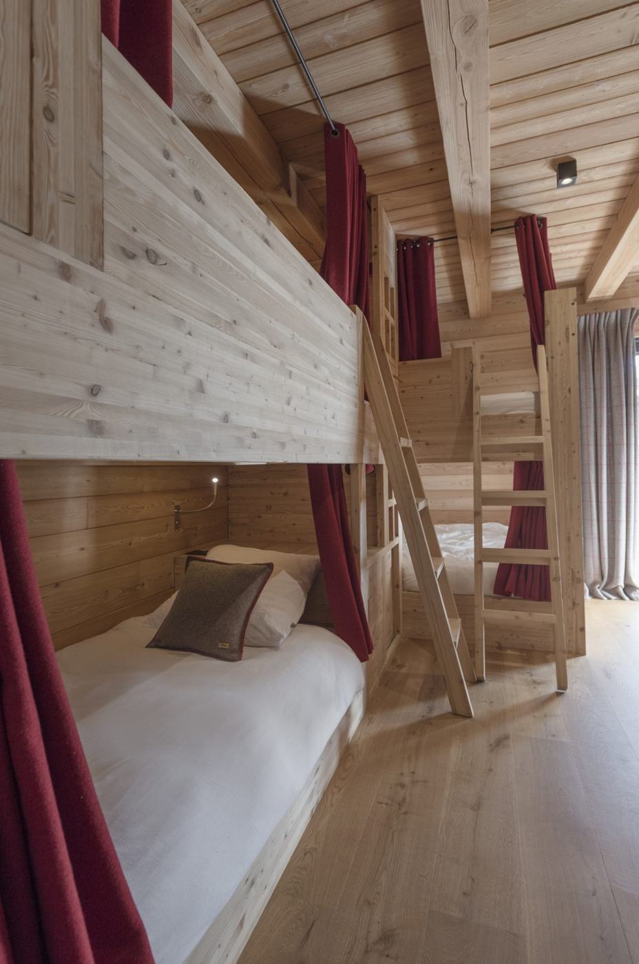 Le Refuge bedroom with larch bunk beds and red curtains