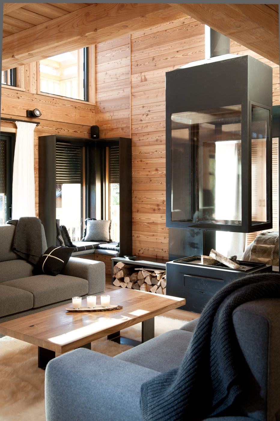 Larch-panelled living room with suspended glass fireplace